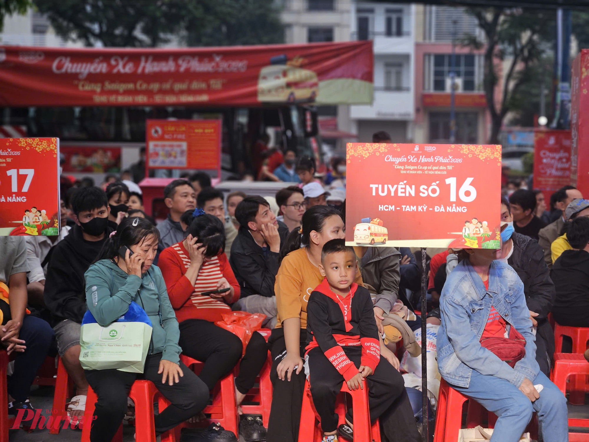 Người dân ngồi theo từng tuyến, chờ gọi tên lên xe trong không khí háo hức trước giờ khởi hành.