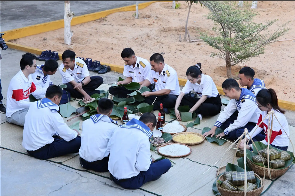 Các cán bộ, chiến sĩ và đoàn công tác cùng gói từng chiếc bánh chưng - Ảnh: Masan