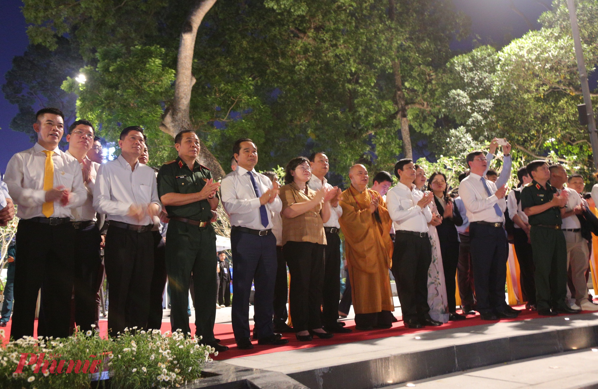 Lãnh đạo TPHCM và các vị đại biểu vỗ tay theo bài hát tưởng niệm nạn nhân COVID-19 - Ảnh: Nguyễn Văn