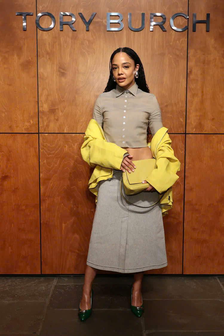 Tessa Thompson ưu tiên phong cách hiện đại và cá tính hơn khi kết hợp áo sơ mi dáng lửng, chân váy midi và áo khoác khoác hờ tông vàng nổi bật. Cách phối màu táo bạo nhưng có tính toán giúp tổng thể vừa thời thượng, vừa mang tinh thần thời trang đương đại của thế hệ trẻ.