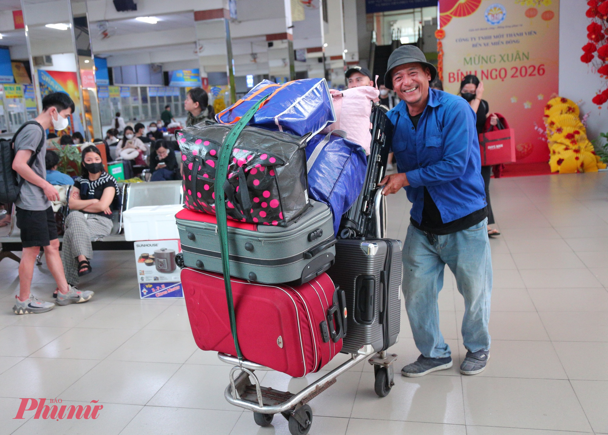 Các nhân viên vận chuyển túc trực trước sảnh, vui vẻ hỗ trợ đẩy xe hành lý, hướng dẫn vị trí đón xe, tạo cảm giác nhẹ nhàng, trật tự trong những ngày cận Tết. Không khí tại Bến xe Miền Đông (cũ) vì thế trở nên dễ chịu hơn, dù vẫn giữ được nhịp độ sôi động đặc trưng của mùa cao điểm cuối năm.