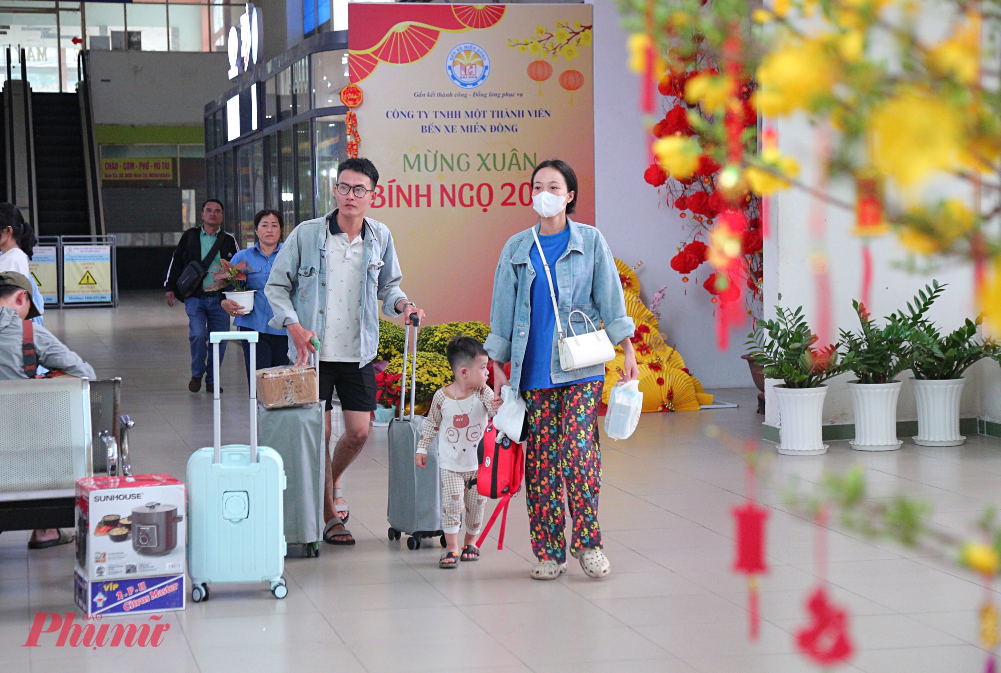 Hành khách thong thả di chuyển vào khu vực nhà chờ, quầy vé, cổng lên xe. Nhiều gia đình mang theo lỉnh kỉnh hành lý nhưng vẫn giữ được tâm trạng thoải mái. 