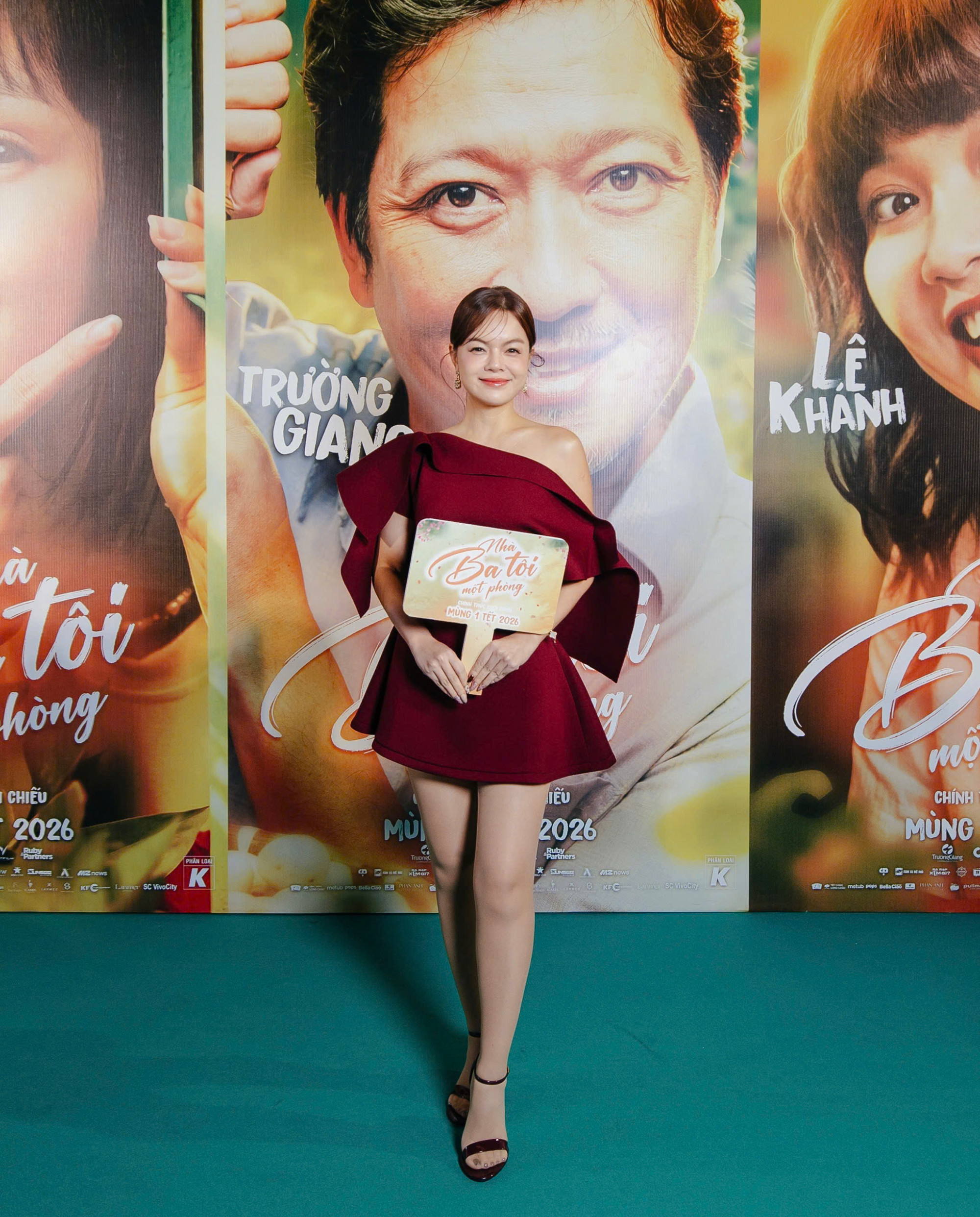 Chiếc đầm ngắn dáng xòe bất đối xứng, thiết kế lệch vai giúp Phạm Quỳnh Anh tự tin khoe bờ vai thanh mảnh, đồng thời tạo điểm nhấn bằng chi tiết bèo mềm mại ở phần tay áo. Gam màu đỏ rượu vang vừa sang trọng vừa tôn da, giúp tổng thể trở nên nổi bật. Phụ kiện tối giản cùng kiểu tóc búi gọn, trang điểm trong veo càng toát lên phong cách trẻ trung, tinh tế của nữ ca sĩ.