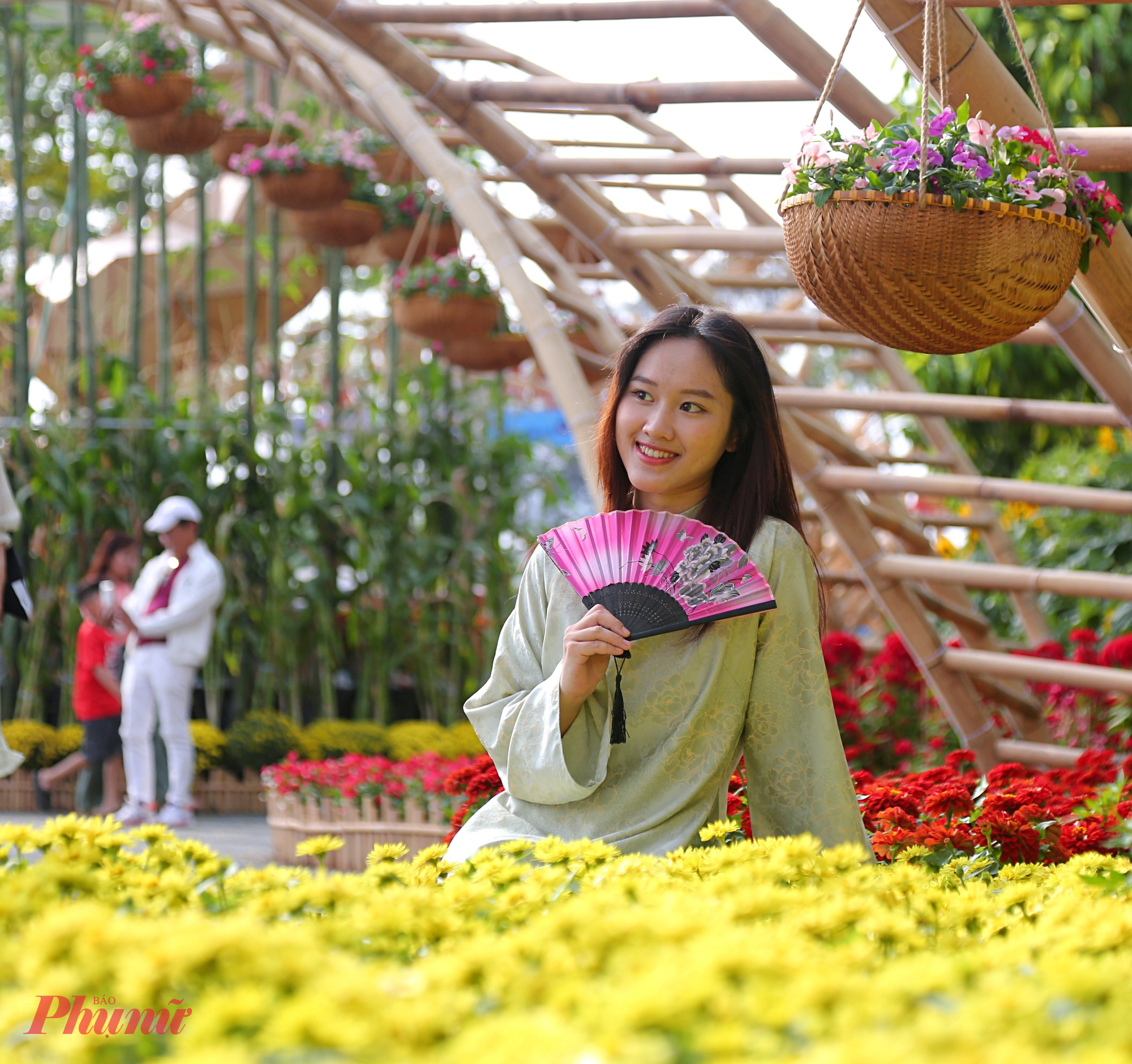Nhiều bạn trẻ diện áo dài rực rỡ đến “check-in” tại đường hoa Phú Mỹ Hưng, tạo nên khung cảnh xuân thêm phần tươi vui. 