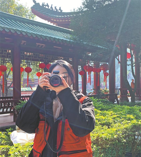 Huang Yaxuan làm nhiếp ảnh gia tình nguyện tại một ngôi đền trong dịp lễ - Ảnh: China Daily