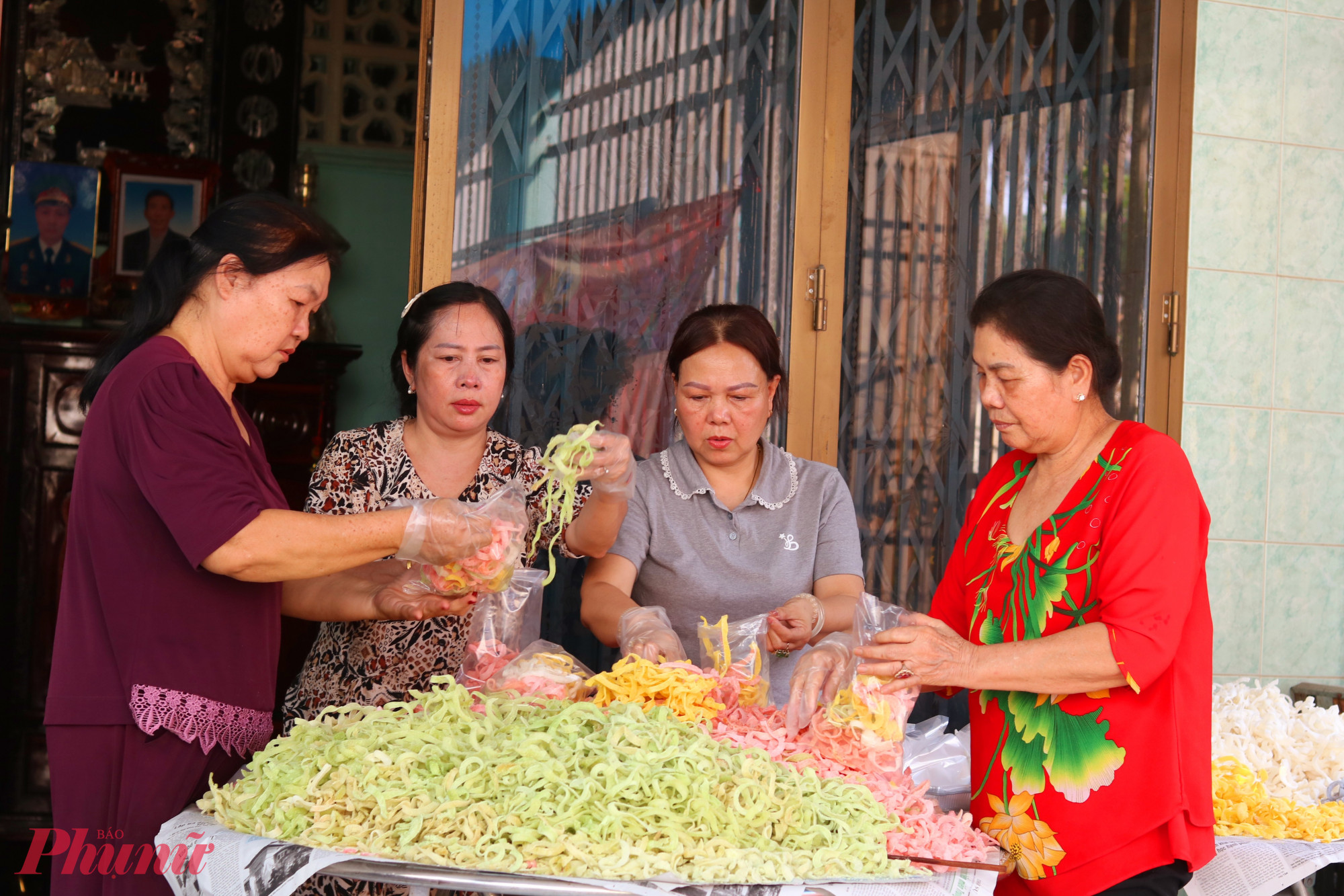 Các bà, các chị cho mứt vào bọc sau đó đóng hộp - Ảnh: Thảo Nguyên