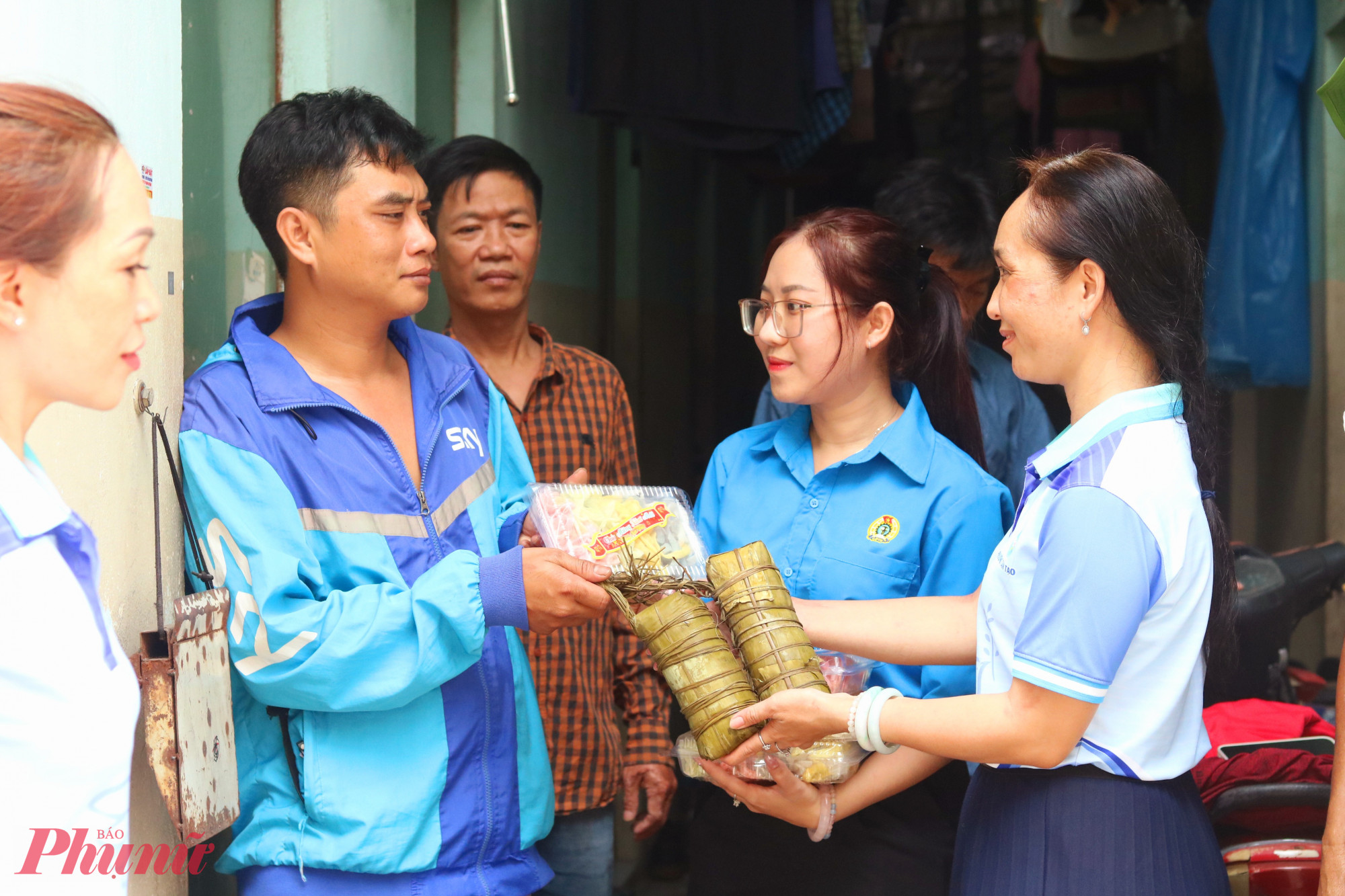 Bà Đinh Thị Hồng Hạnh – Phó chủ tịch Ủy ban MTTQ Việt Nam phường Tân Tạo, Chủ tịch Hội LHPN phường (bìa phải) và bà Lâm Thị Xuân Ngọc – Phó chủ tịch Công đoàn phường Tân Tạo (thứ 2, từ phải qua) cùng đến các khu nhà trọ tặng bánh, mứt cho người lao động - Ảnh: Thảo Nguyên 