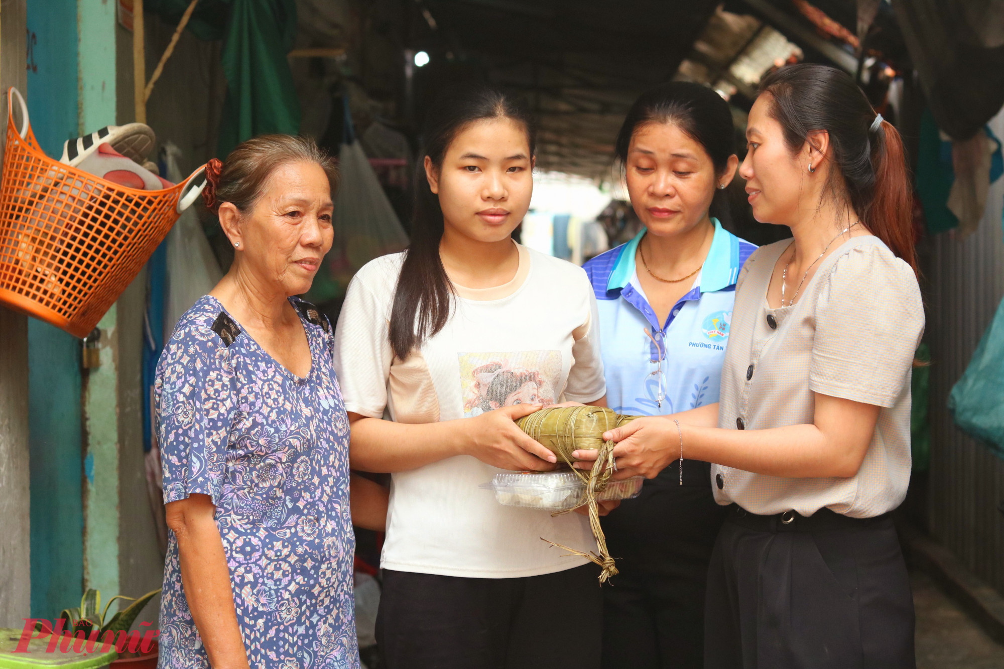 Bánh, mứt được trao cho các chị em trong khu nhà trọ của bà Nguyễn Minh Hoàng (bìa trái) - Ảnh: Thảo Nguyên