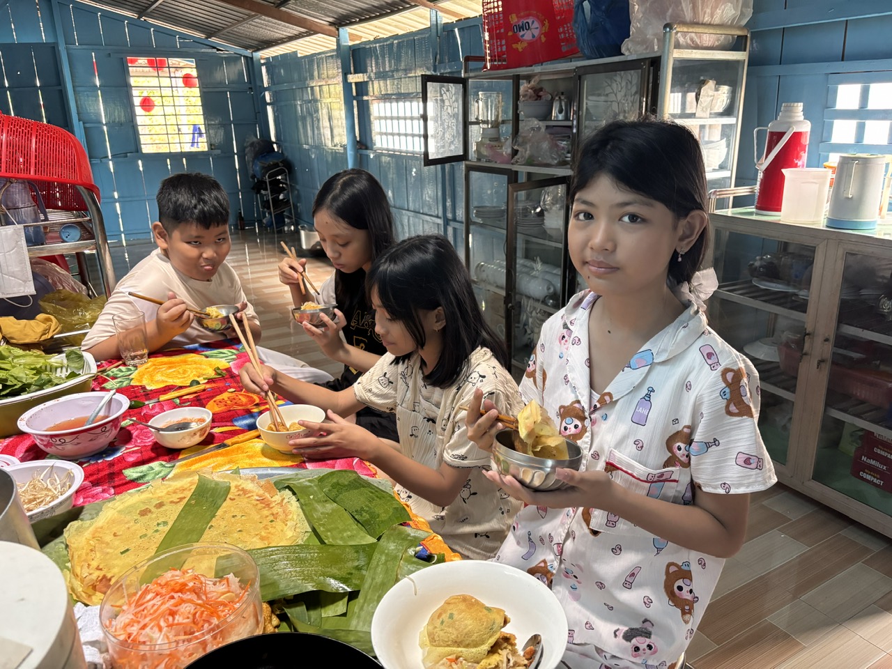 Trẻ con trong xóm đủ sác thái vui hờn kéo đến nhà bà Tư Phô ăn bánh xèo. Ảnh TD