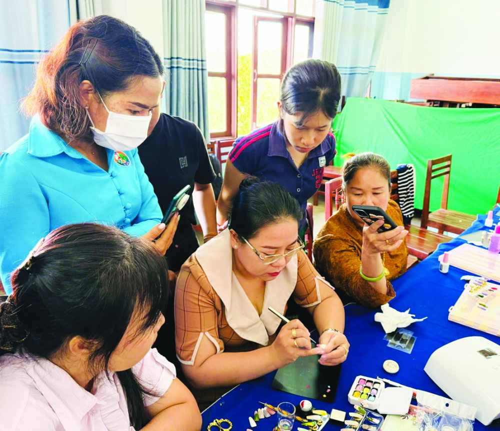 Những điểm sáng trong đối ngoại nhân dân của phụ nữ TPHCM Chị Dương Thị Hồng Nhung (ngồi, thứ hai từ trái qua) - giáo viên phụ trách môn gel nail art - hướng dẫn các học viên Lào kỹ thuật làm móng gel - Ảnh: Ngọc Trăm