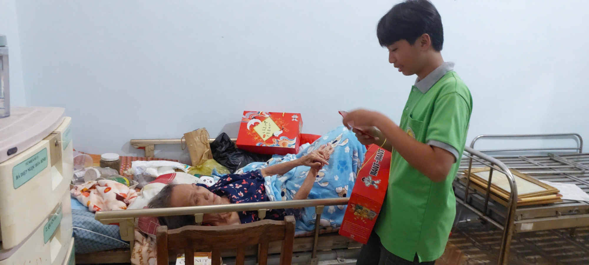 Trao quà tận giường cho các cụ đi lại khó khăn - Ảnh: Bích Ngân 