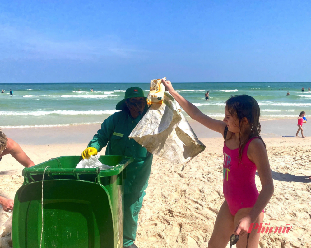 Một em bé nhặt được rác khi đang bơi - Ảnh: HP