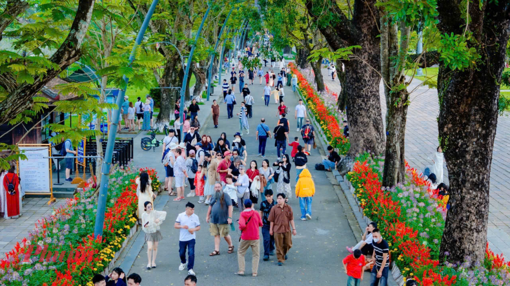 Dòng người nối nhau thong thả: gia đình diện áo dài chụp ảnh đầu năm, nhóm bạn trẻ du xuân, xen lẫn các đoàn khách quốc tế háo hức khám phá Hoàng cung xưa.
