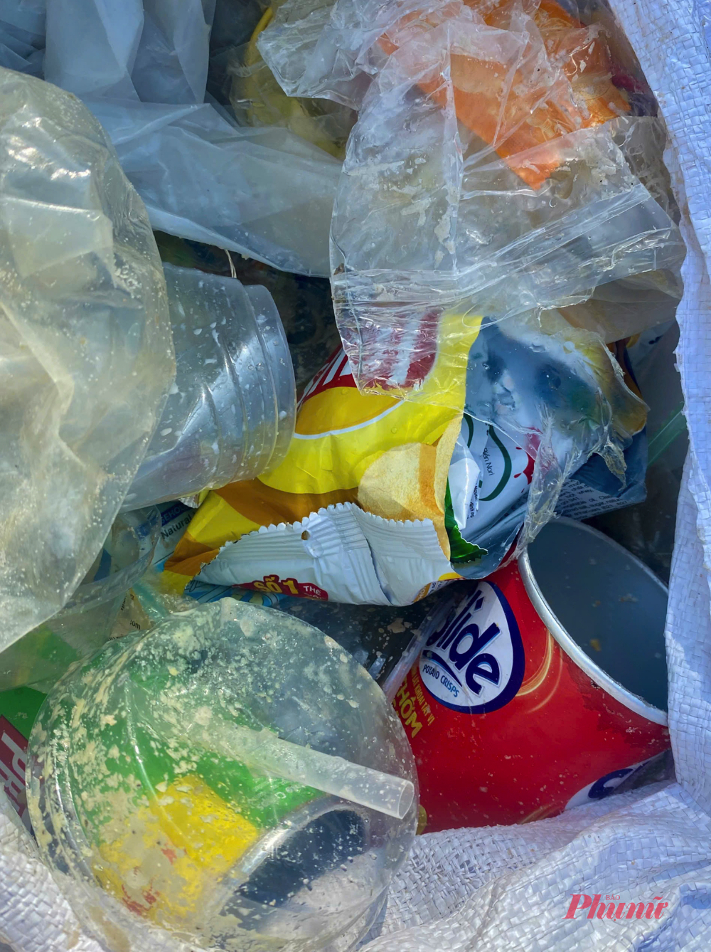 Cận cảnh lon nước ngọt, ống hút, ly nhựa, vỏ thức ăn - Ảnh: HP