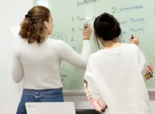 Hai nữ sinh trưởng thành xuống làm việc trên bảng trắng. Ảnh: Douyin