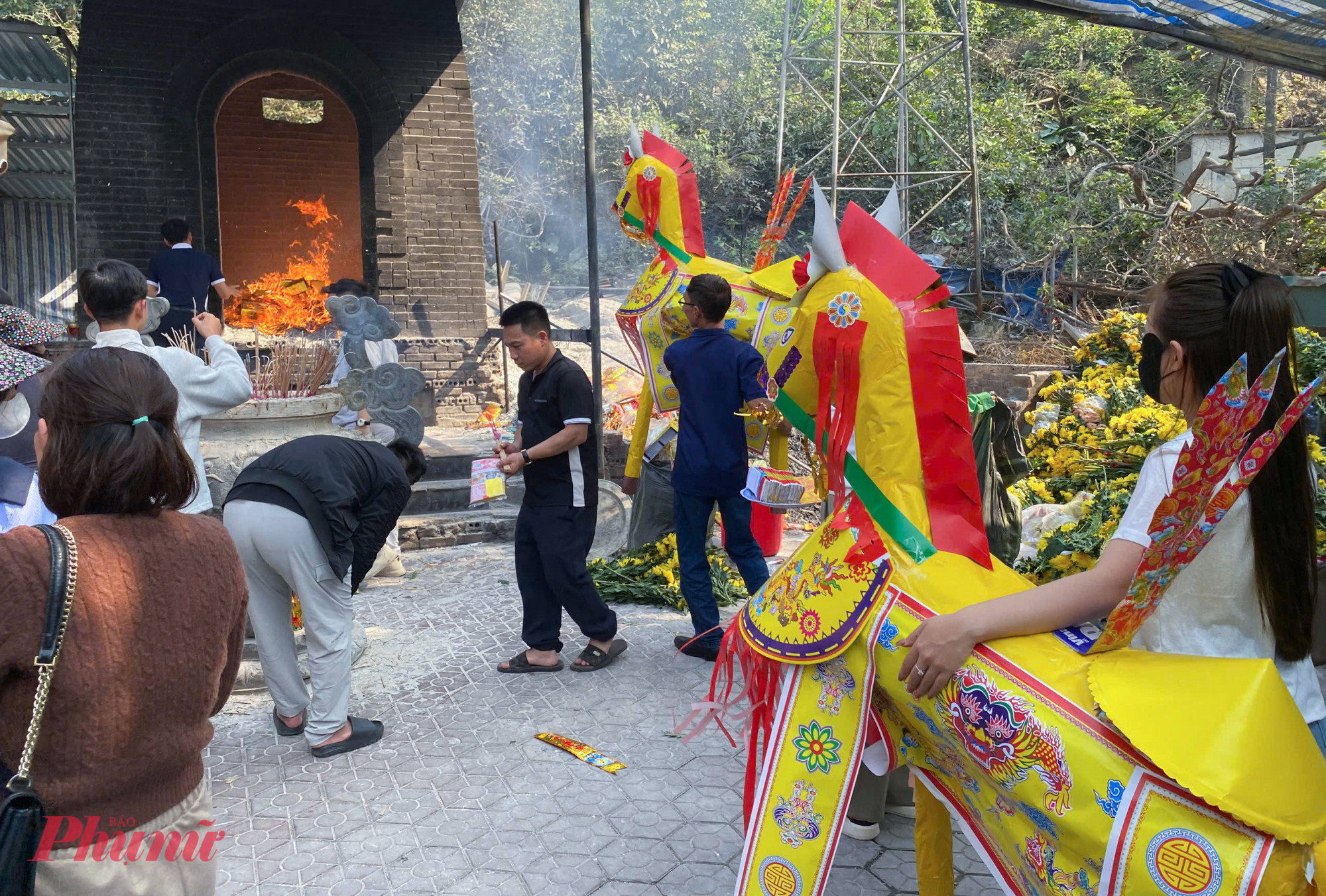 Sau khi làm lễ, du khách mang ngựa giấy đến lò hóa vàng mã bên cạnh đền để đốt.