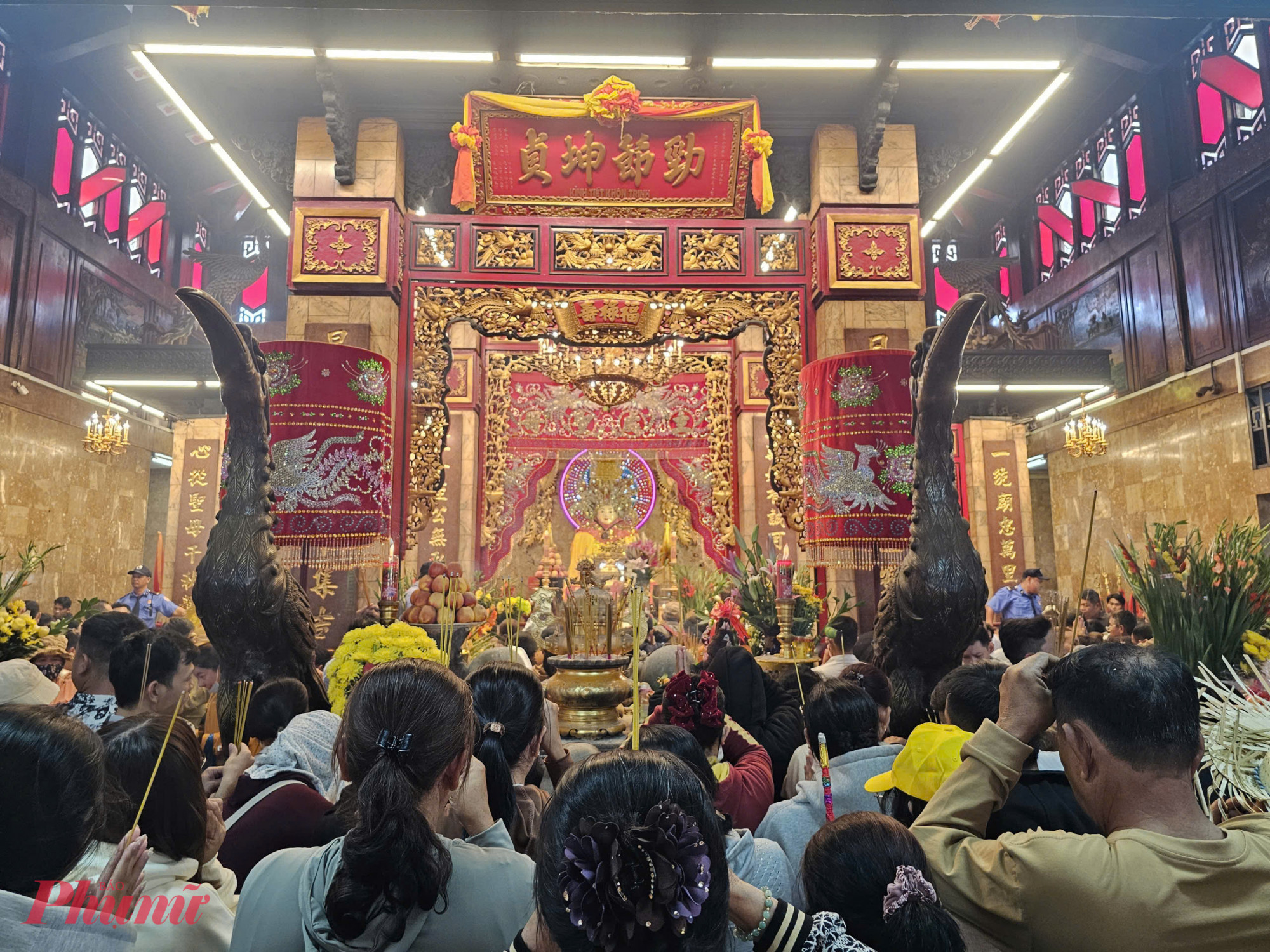 Tại khu vực sảnh thờ Bà, nhiều người dân chen nhau để đặt trái cây, hoa và heo quay để cúng Bà xin tài lộc.