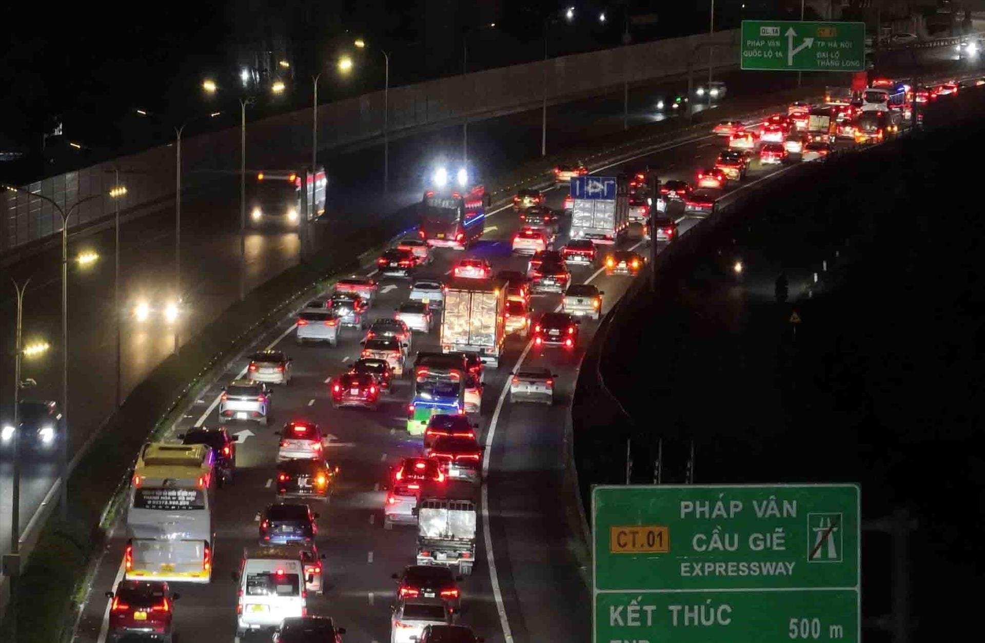 Các phương tiện nối đuôi nhau di chuyển khó khăn đoạn kết thúc cao tốc Pháp Vân - Cầu Giẽ hướng vào trung tâm Thủ đô trong tối 21/2. Ảnh: Phạm Kiên