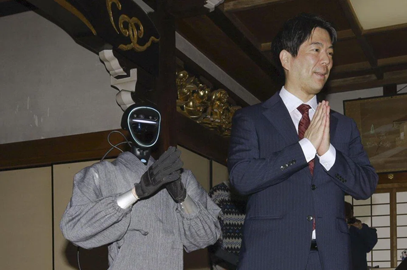 Giáo sư Seiji Kumagai của Đại học Kyoto đang giới thiệu robot tu sĩ hình người — Ảnh: Kyodo News 
