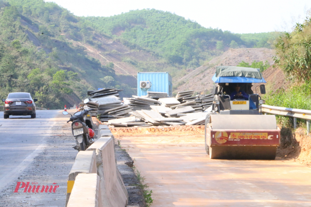 Ở khu vực thảm bê tông nhựa, các tổ công nhân phối hợp nhịp nhàng. Người kiểm tra cao độ, người điều chỉnh máy rải, người cẩn thận đo độ chặt từng lớp mặt đường. Tiếng động cơ hòa cùng tiếng trao đổi dứt khoát qua bộ đàm tạo nên nhịp điệu lao động khẩn trương nhưng đầy khí thế.