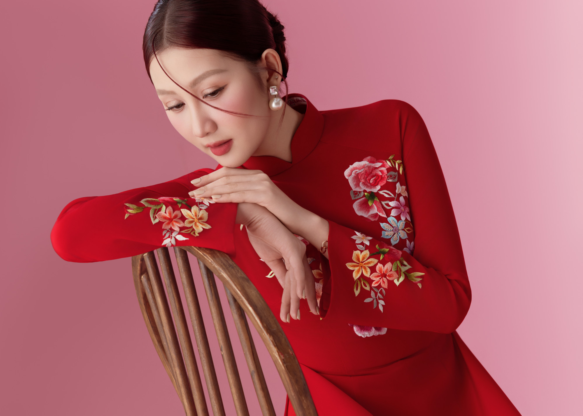 Nàng hậu ghi điểm với vẻ đẹp đằm thắm, mặn mà. Thiết kế áo dài đỏ thêu hoa rực rỡ trên nền vải trơn càng làm nổi bật làn da sáng và thần thái của Quế Anh. Gương mặt thanh tú được tôn lên bởi lối trang điểm tinh tế: lớp nền mịn lì, má hồng phớt nhẹ tạo cảm giác trong trẻo, đôi môi đỏ trầm hài hòa với tổng thể.