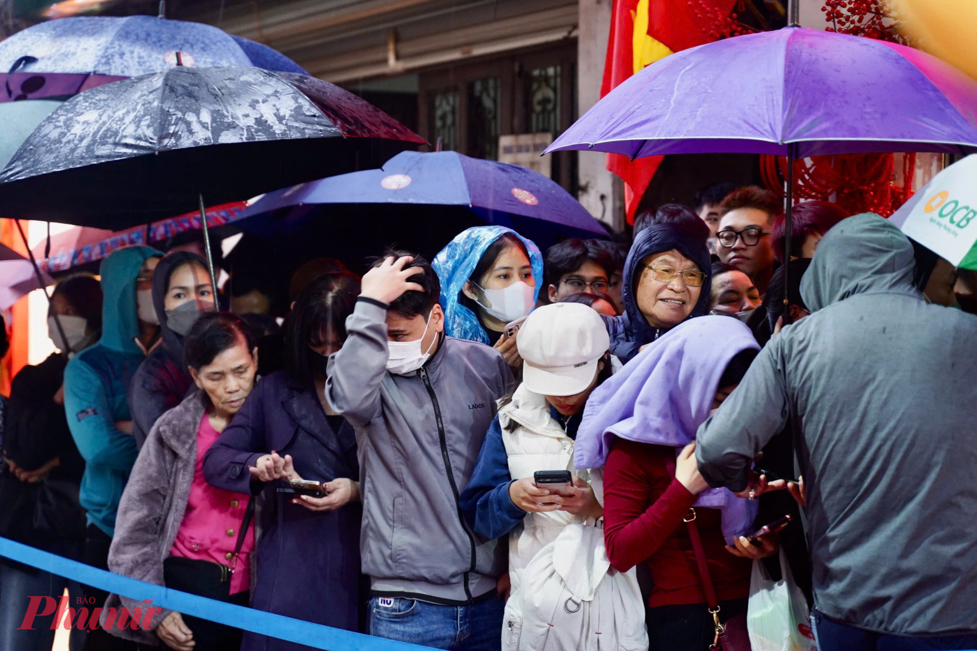 Đến sáng, trời Hà Nội đổ mưa lớn, hàng dài người vẫn kiên nhẫn xếp hàng chờ đến lượt vào trong quầy giao dịch.