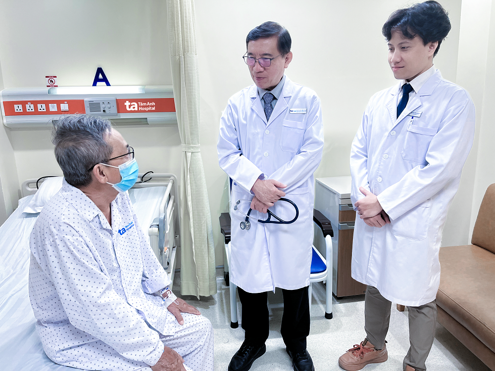 GS.TS.BS Võ Thành Nhân (giữa) hỏi thăm sức khỏe bệnh nhân sau một ngày được can thiệp cấy máy tạo nhịp không dây thế hệ mới nhất - Ảnh: BVĐK Tâm Anh