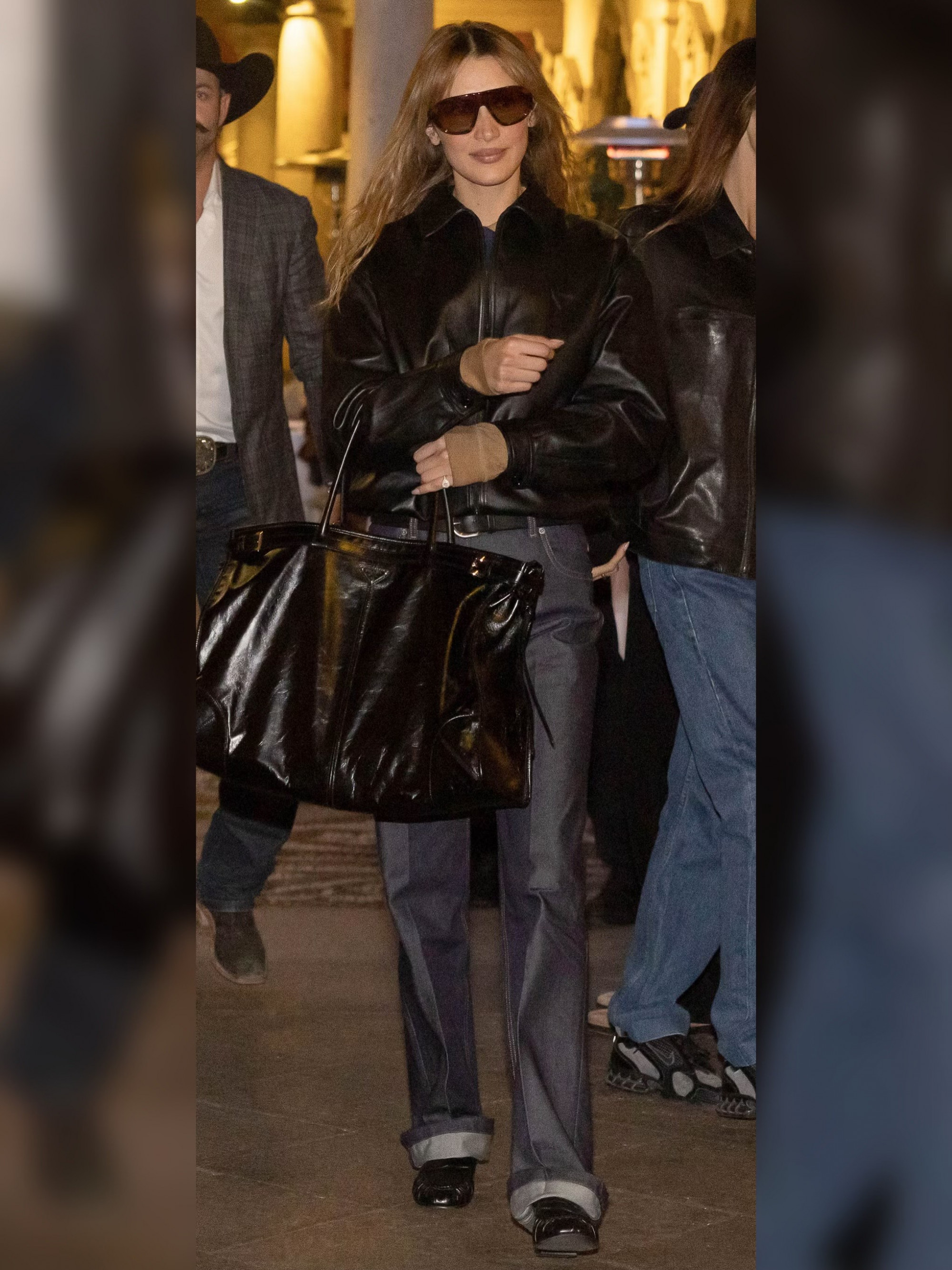 Trong lần xuất hiện tại Milan Fashion Week năm nay, Bella Hadid diện áo khoác da dáng ngắn với phom đứng, kết hợp quần jeans ống suông gập gấu, tạo cảm giác vừa phóng khoáng vừa cá ti ha. Bảng màu trung tính giúp tổng thể trông mạnh mẽ nhưng không hề cứng nhắc. Phụ kiện được nữ siêu mẫu tiết chế tối đa, chỉ với kính râm bản lớn và chiếc túi da oversized cũng đủ tạo điểm nhấn quyền lực, đúng tinh thần cool girl đặc trưng của Bella.