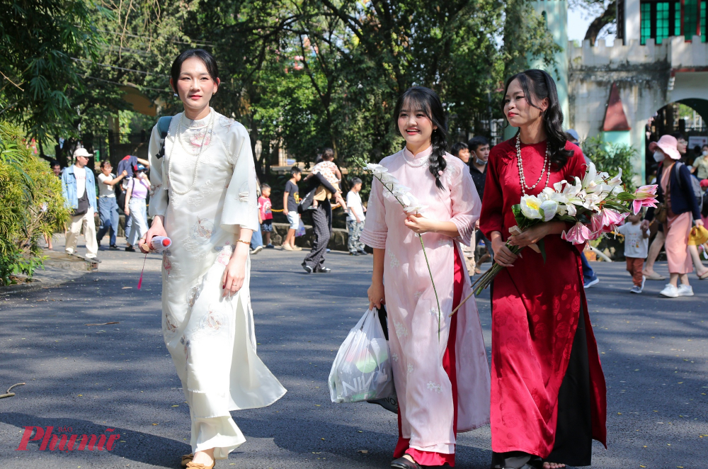 Người dân, du khách mặc áo dài chụp ảnh Tết tại Thảo Cầm Viên. Ảnh: Tứ Quý