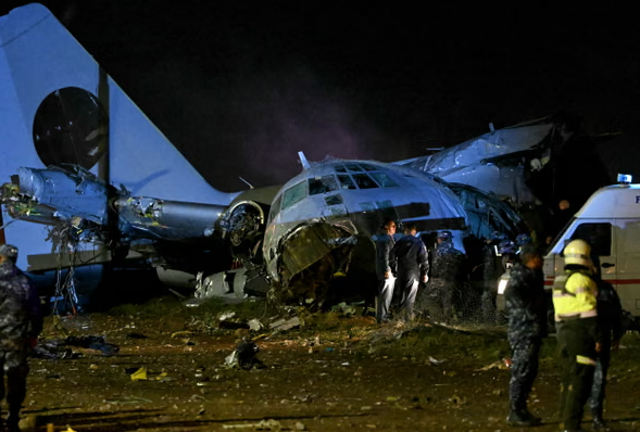 Các nhân viên quân sự bảo vệ đống đổ nát của một máy bay quân sự bị rơi ở el Alto, Bolivia, hôm thứ Sáu, làm rải rác các tờ tiền. Ảnh: Aizar Raldes / AFP / Getty Images
