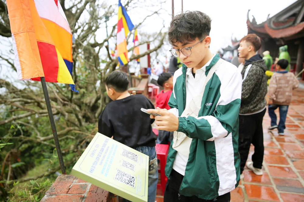 Du khách tìm hiểu thông tin về khu di tích lịch sử và danh thắng Yên Tử (tỉnh Quảng Ninh) qua mã QR - ẢNH: QUANG SƠN