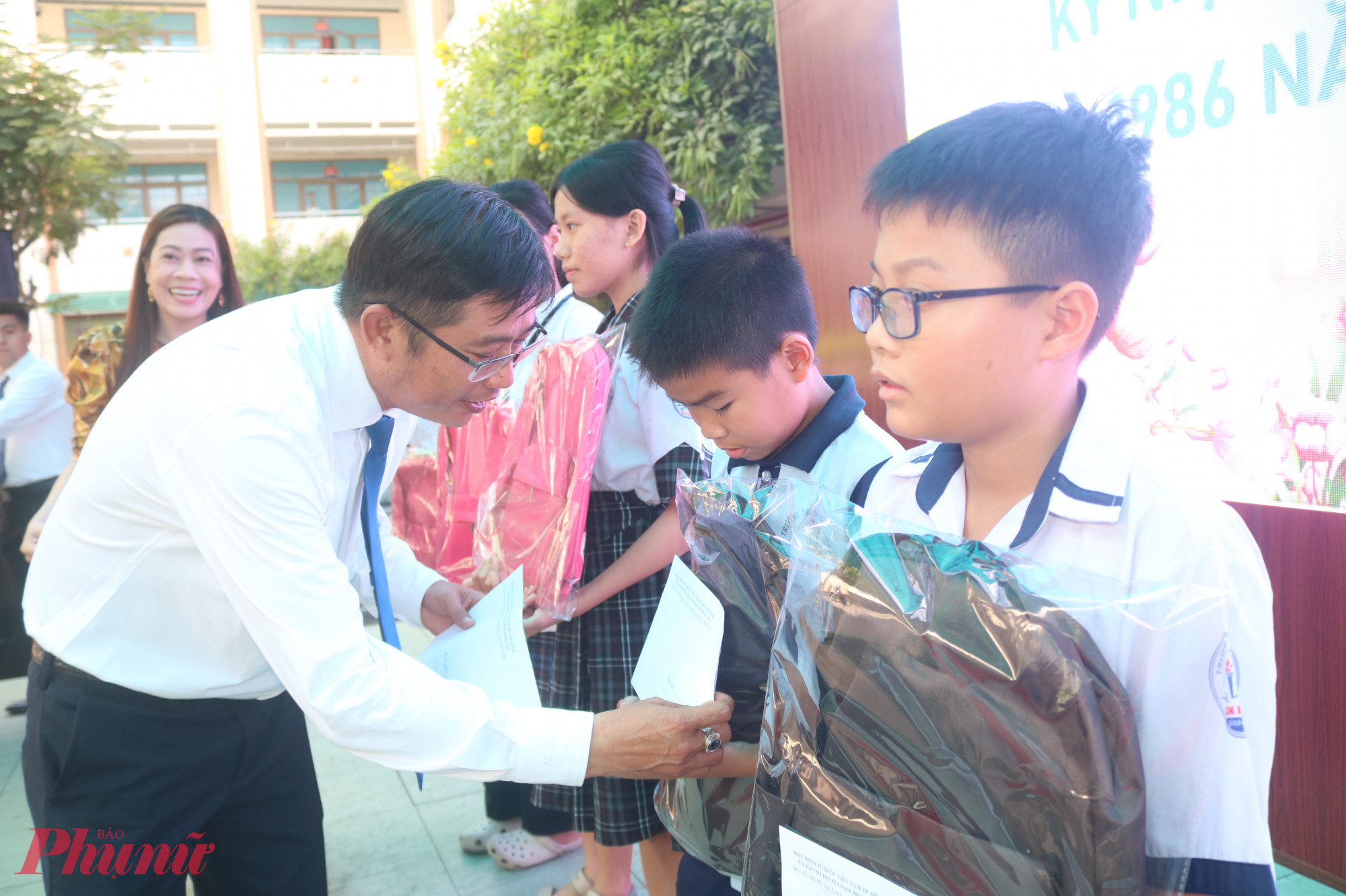 Ông Nguyễn Quang Hưng – Phó bí thư thường trực đảng ủy phường Bình Tân – trao học bổng cho các em học sinh - Ảnh: Mẫn Nhi