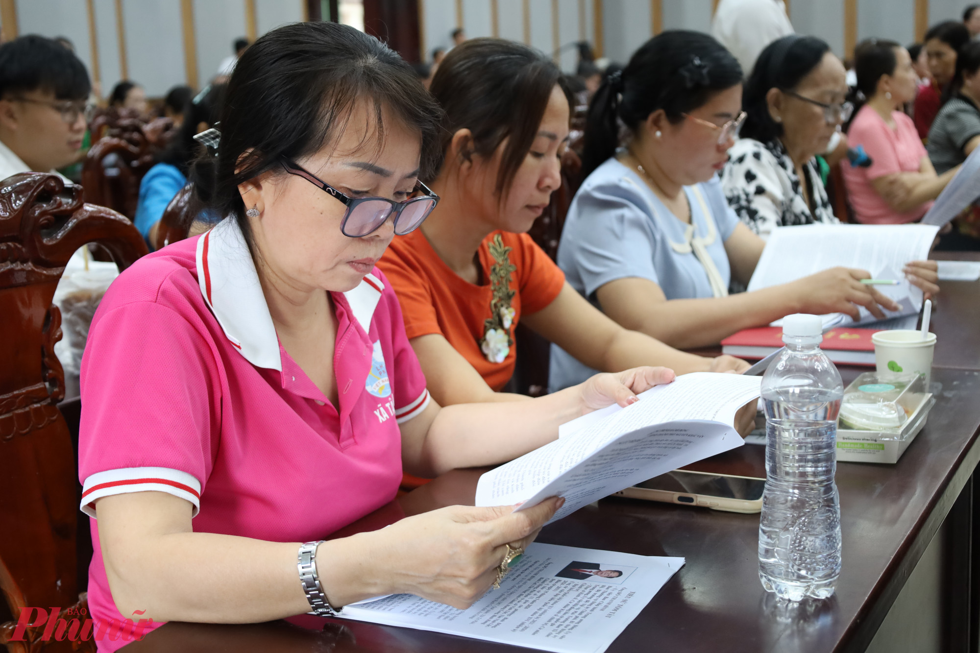 Cử tri xã Tân Nhựt theo dõi và lắng nghe chương trình hành động của các ứng cử viên - Ảnh: Thanh Tâm