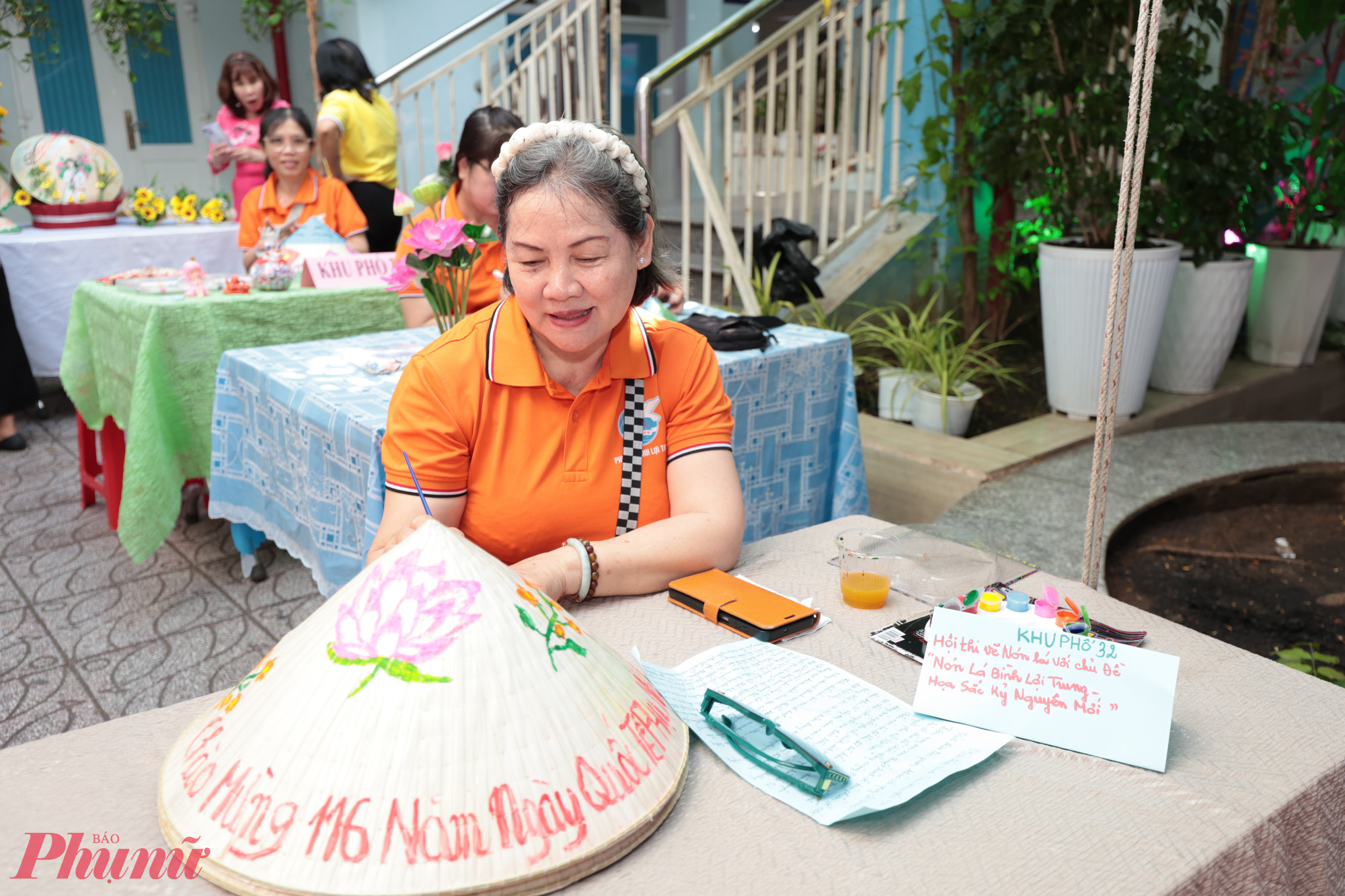 Hội viên phụ nữ tỉ mỉ thể hiện phần thi trang trí nón lá