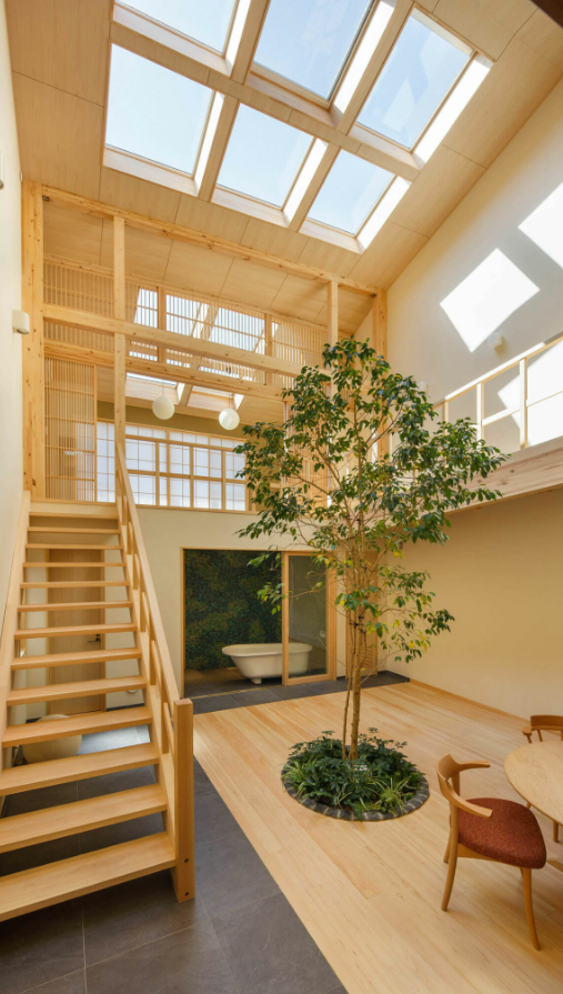 Ngôi nhà độc đáo này ở Kyoto, Nhật Bản, do 07BEACH thiết kế. Nó có không gian sinh hoạt mở cho phép cha mẹ có thể trông chừng những đứa trẻ hiếu động của mình bất kể chúng đang ở đâu. Do các ngôi nhà xung quanh được xây dựng sát nhau, khu đất không còn chỗ cho một khu vườn thực sự, điều này buộc nhà thiết kế phải suy nghĩ sáng tạo hơn. Giải pháp của họ là gì? Họ đã thiết kế một phòng khách chính có trần cao gấp đôi với giếng trời phía trên lọc ánh sáng tự nhiên chiếu xuống cây xanh ở trung tâm trong nhà, tạo cảm giác không gian như được kết nối với ngoài trời. Ảnh: @Yosuke Ohtake.