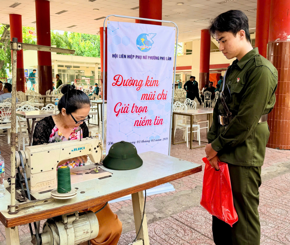 Tương tự, tại Trường THPT Mạc Đĩnh Chi, phường Phú Lâm, Hội LHPN phường cũng tổ chức gian hàng cắt tóc và chỉnh sửa quân trang miễn phí. Cứ vài phút lại có một tân binh ghé lại để sửa quần áo, cắt tóc. Các dì, các chị phụ nữ tỉ mỉ chăm chút từng bộ đồ để các em có diện mạo gọn gàng, chỉnh tề trước ngày nhập ngũ.