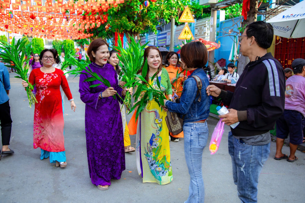 Hội viên phụ nữ phường tặng cây xanh cho du khách tham quan lễ hội Rằm tháng Giêng tại địa phương