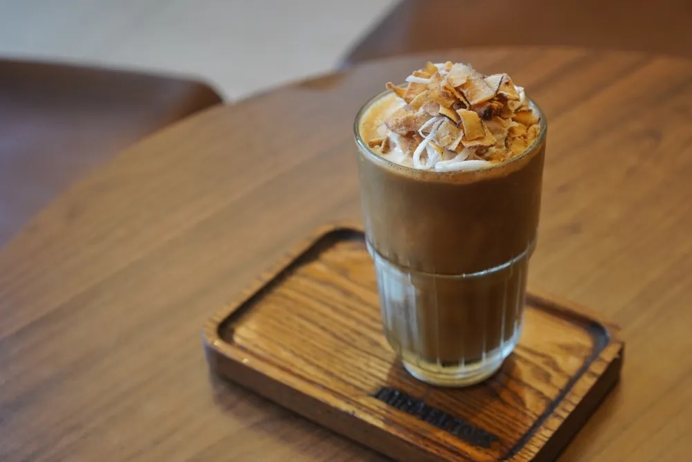 Cà phê dừa. Đây là ly sinh tố dừa và cho cà phê đen đậm đặc lên trên. Bạn sẽ cảm nhận được vị béo ngậy của dừa và vị đắng của cà phê Việt Nam. Đây là món tráng miệng tuyệt vời hơn là thức uống khởi đầu ngày mới. Bạn có thể thưởng thức cà phê dừa ở quán cà phê Faifo - 130 Trần Phú. Ngồi trên sân thượng bạn nhìn bao quát  những con phố rợp bóng cây xanh mang đậm kiến trúc Pháp màu vàng của khu phố cổ. Nếu bạn muốn vừa uống cà phê dừa vừa ngắm đồng lúa xanh rì, đón làn gió mát mẻ thì đến quán cà phê Xóm Chiêu ở 55 Lê Thánh Tông. 