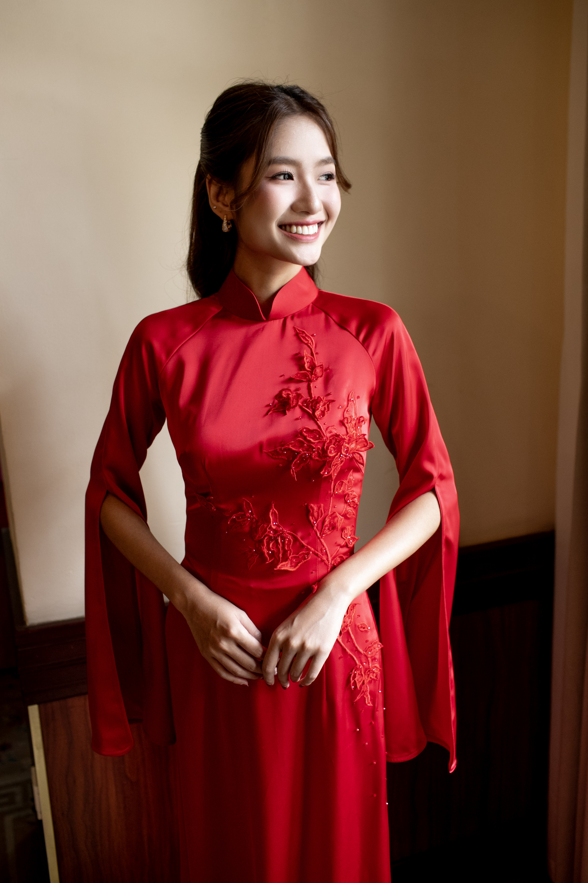 Về trang điểm, Thanh Hà lựa chọn phong cách trong trẻo, làm nổi bật nét đẹp tự nhiên thay vì tạo khối cầu kỳ. Lớp nền mỏng nhẹ, tiệp da giúp gương mặt giữ được độ căng mịn, tươi tắn. Phần má được nhấn nhẹ bằng tông hồng đào, tạo hiệu ứng ửng hồng khỏe khoắn, hài hòa với sắc đỏ của áo dài.