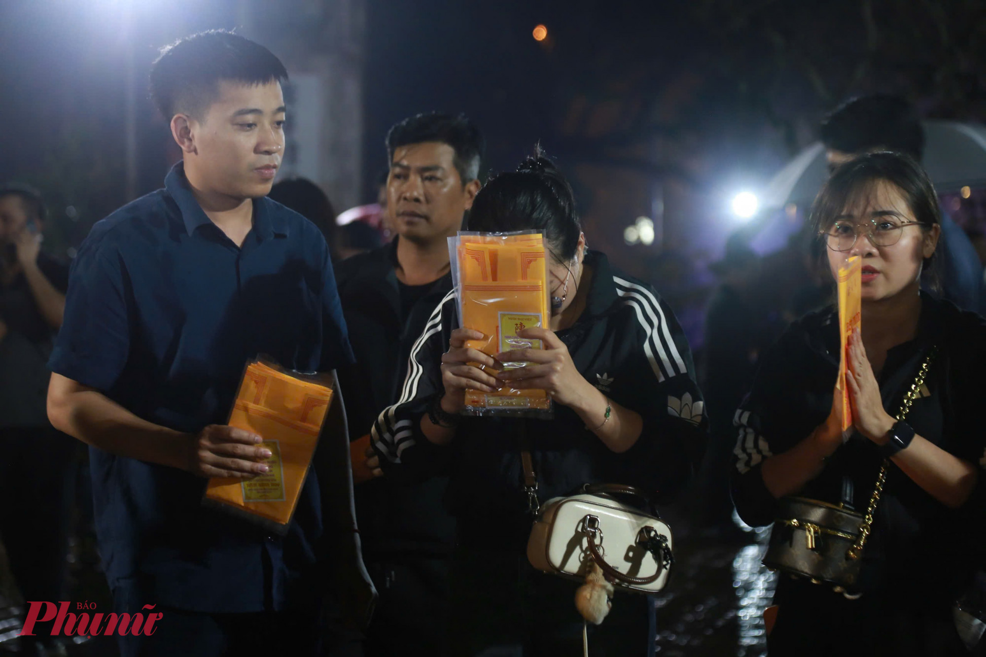 Sau khi nhận ấn, nhiều người dừng lại trước sân đền, chắp tay làm lễ cầu bình an, may mắn và thuận lợi trong năm mới.