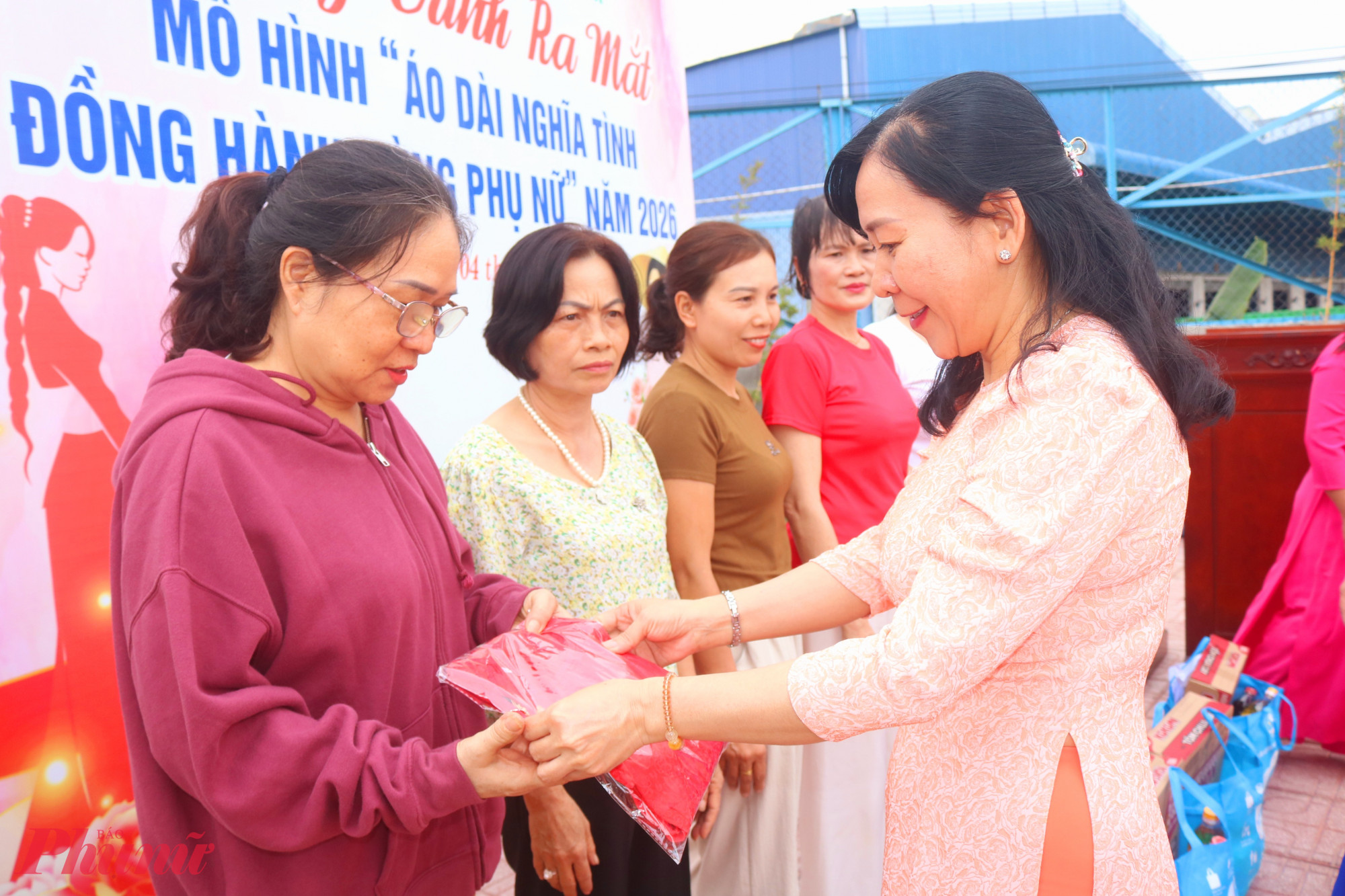 Bà Dương Thúy Huyền – Phó bí thư thường trực Đảng ủy phường Bình Hòa – trao áo dài từ tủ “Áo dài nghĩa tình” của hội cho các chị em - Ảnh: Mẫn Nhi
