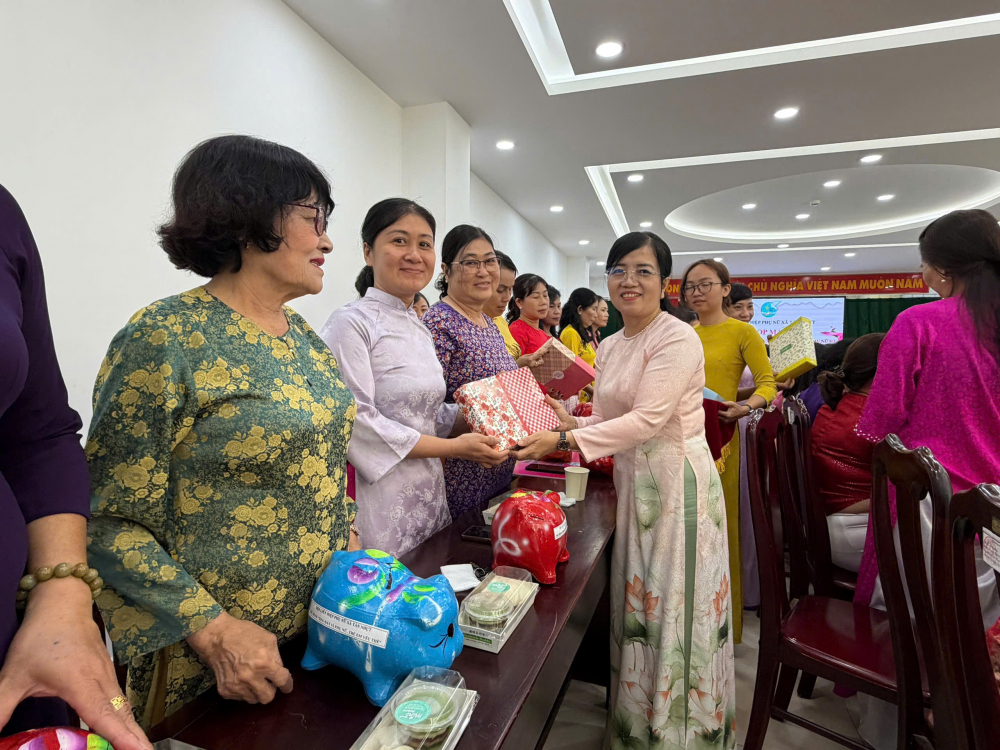 Bà Phan Thị Cẩm Nhung - Phó bí thư Thường trực Đảng ủy xã Tân Nhựt trao quà đến các chi hội trưởng - Ảnh: NH