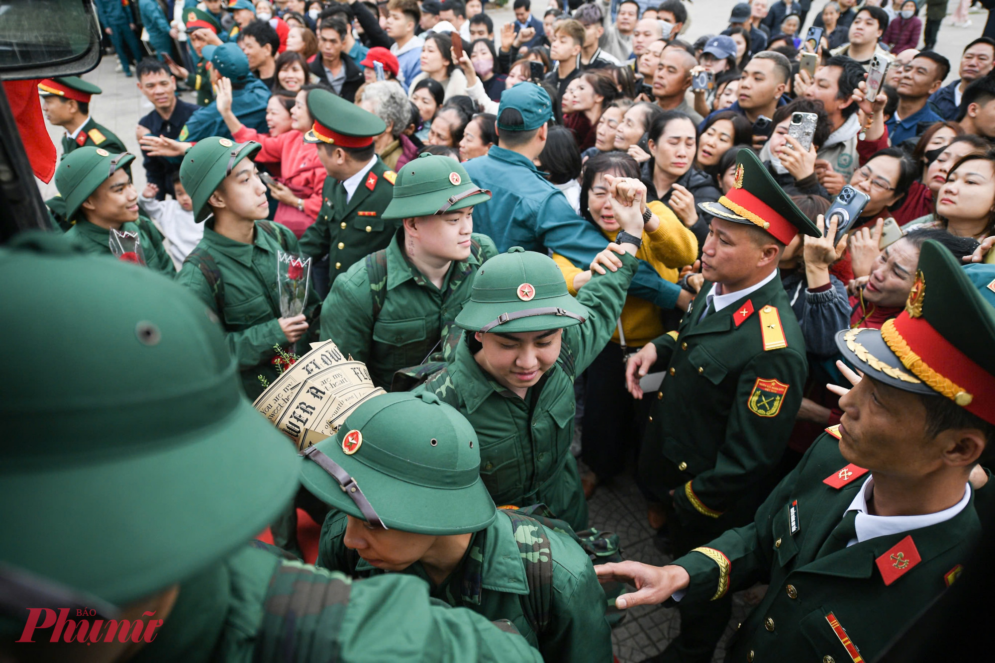 Thanh niên lên đường nhập ngũ nở nụ cười rạng rỡ, thể hiện quyết tâm và tinh thần sẵn sàng cống hiến.