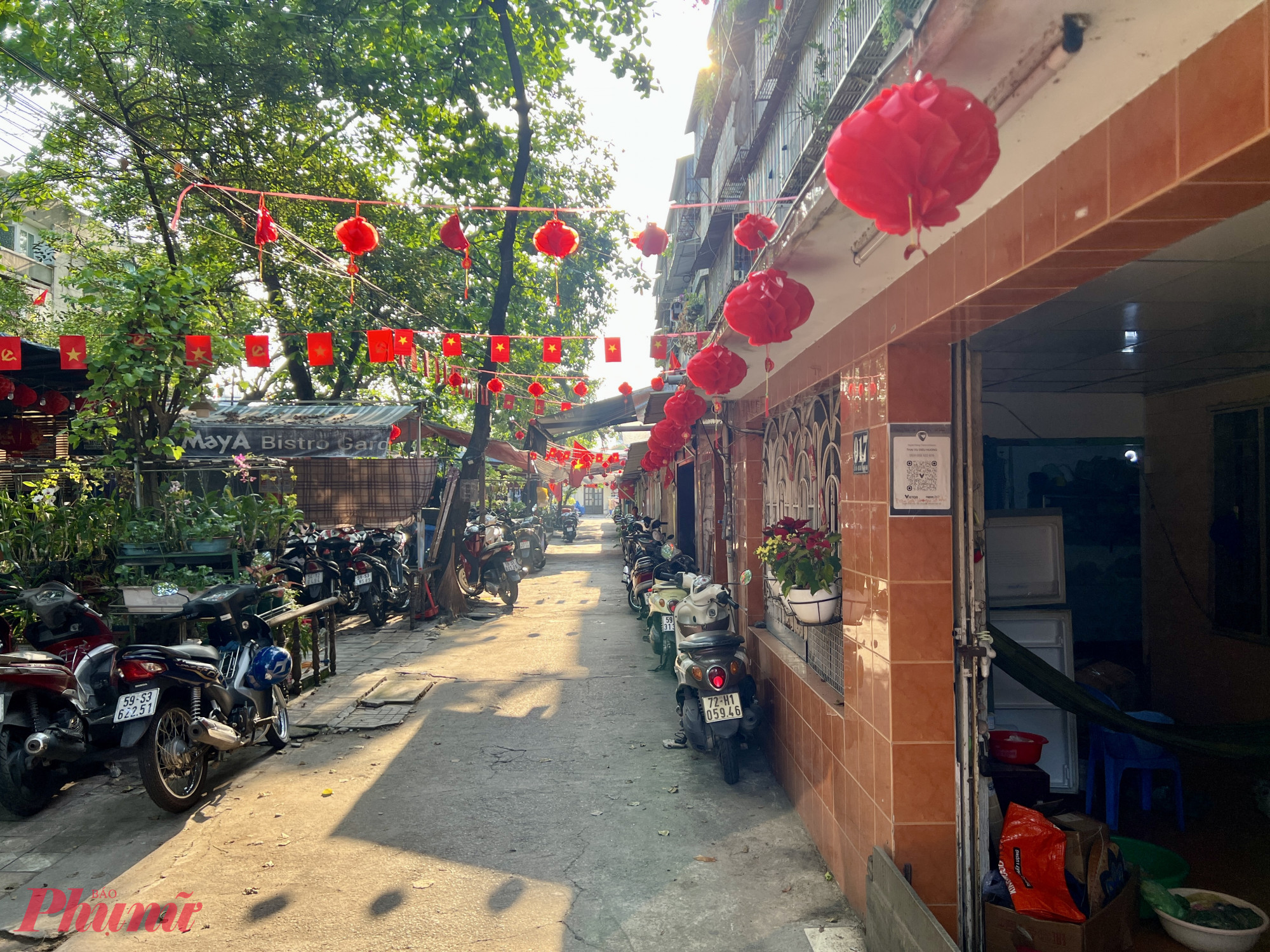 Một góc sân nhỏ trước Lô VIII người dân làm đủ nghề mưu sinh từ giữ xe, sửa quần áo, kinh doanh quán nước, ăn uống,... Ảnh: Quốc Thái