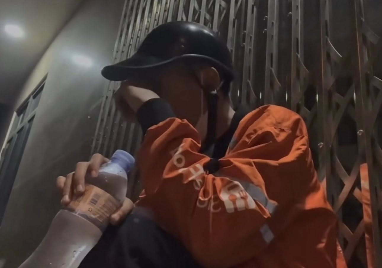 Hình ảnh anh shipper đang nghỉ bên đường, giữa đêm khuya (Ảnh Internet)