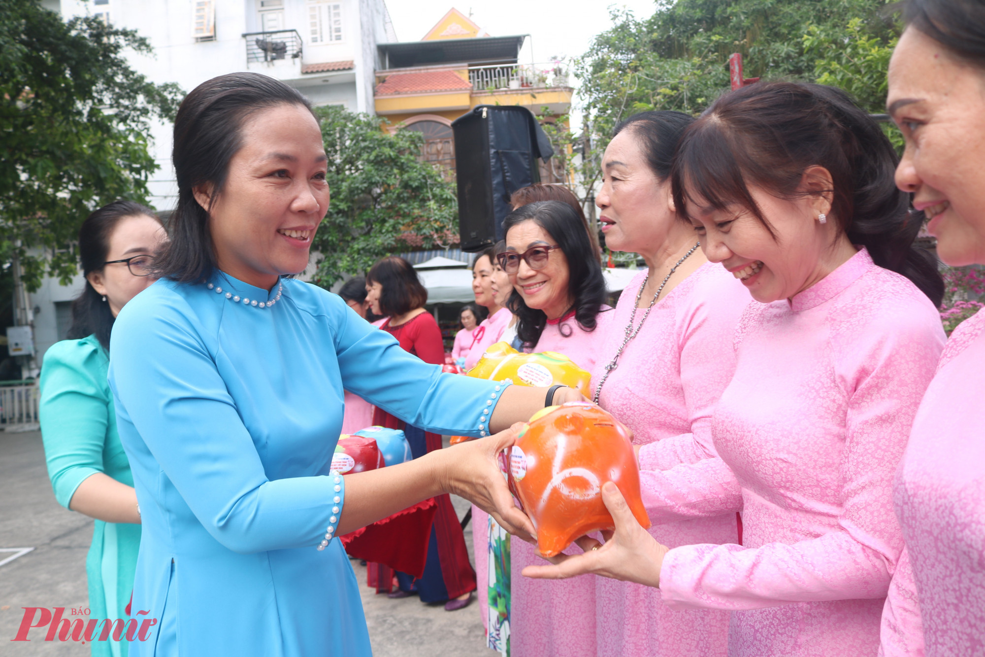 Bà Huỳnh Thị Thu Cúc – Trưởng bộ phận Hỗ trợ phụ nữ phát triển kinh tế, Hội LHPN TPHCM – trao heo đất đến đại diện các chi hội - Ảnh: Mẫn Nhi