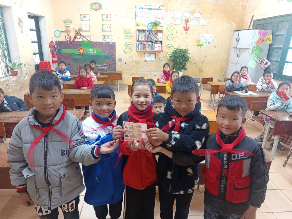 Học sinh Trường Phổ thông Dân tộc bán trú Tiểu học và THCS Khấu Ly (xã Phình Hồ, tỉnh Lào Cai) háo hức nhận tiền mừng tuổi của cô giáo sau kỳ nghỉ tết - Ảnh: H.T