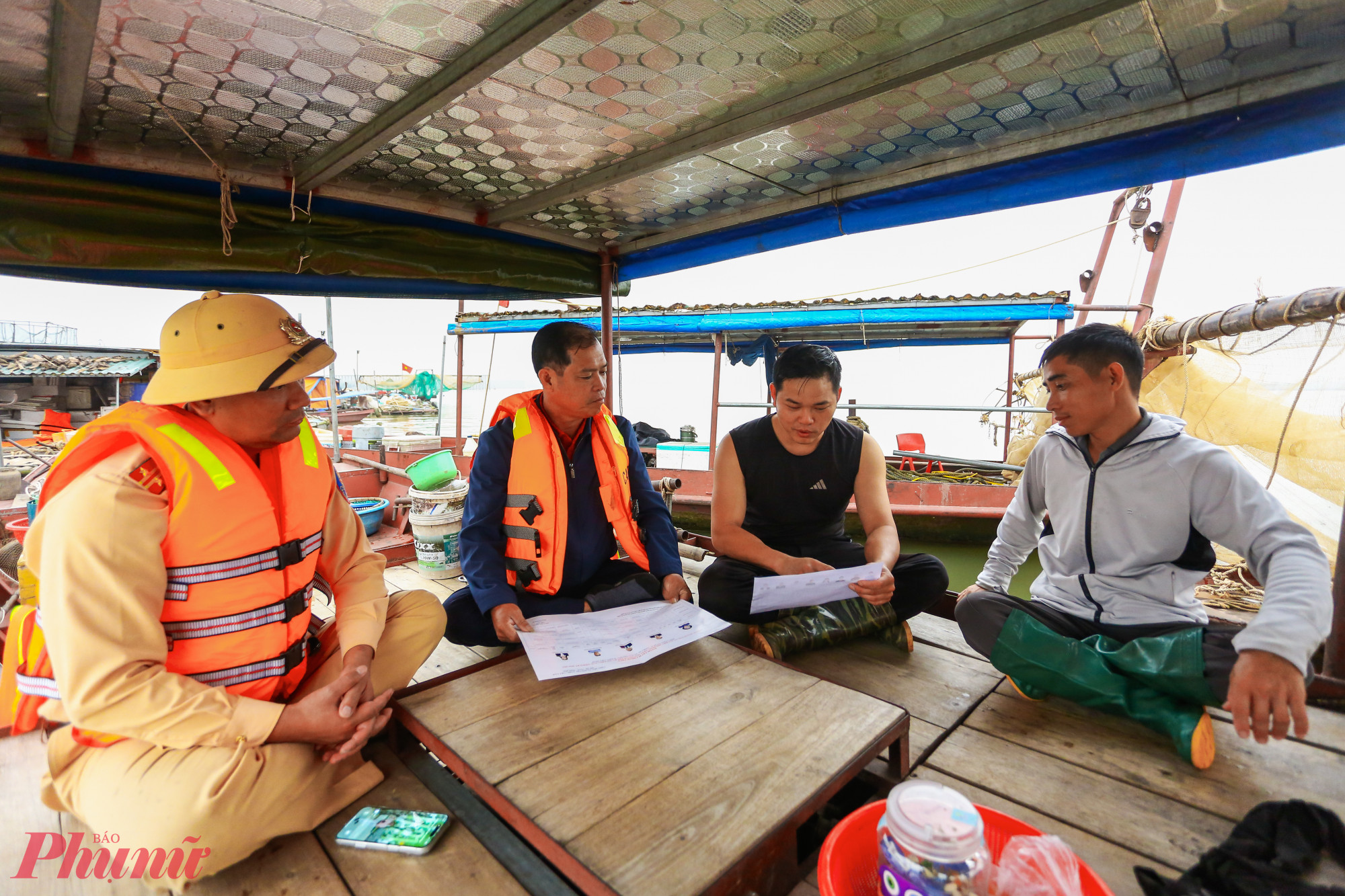 Ông Trần Văn Hải (áo xanh) hướng dẫn cử tri kiểm tra danh sách đại biểu.