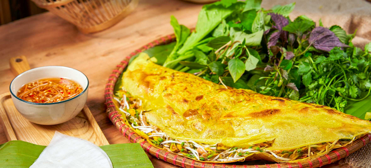 Bánh xèo được ăn cùng các loại rau thơm. Rau thơm theo mùa ở mỗi vùng cũng góp phần định hình hương vị của bánh xèo. Nước mắm ăn kèm được coi là “linh hồn” của bánh và cũng có vị khác nhau theo tùy theo vùng miền - Ảnh: Michelin