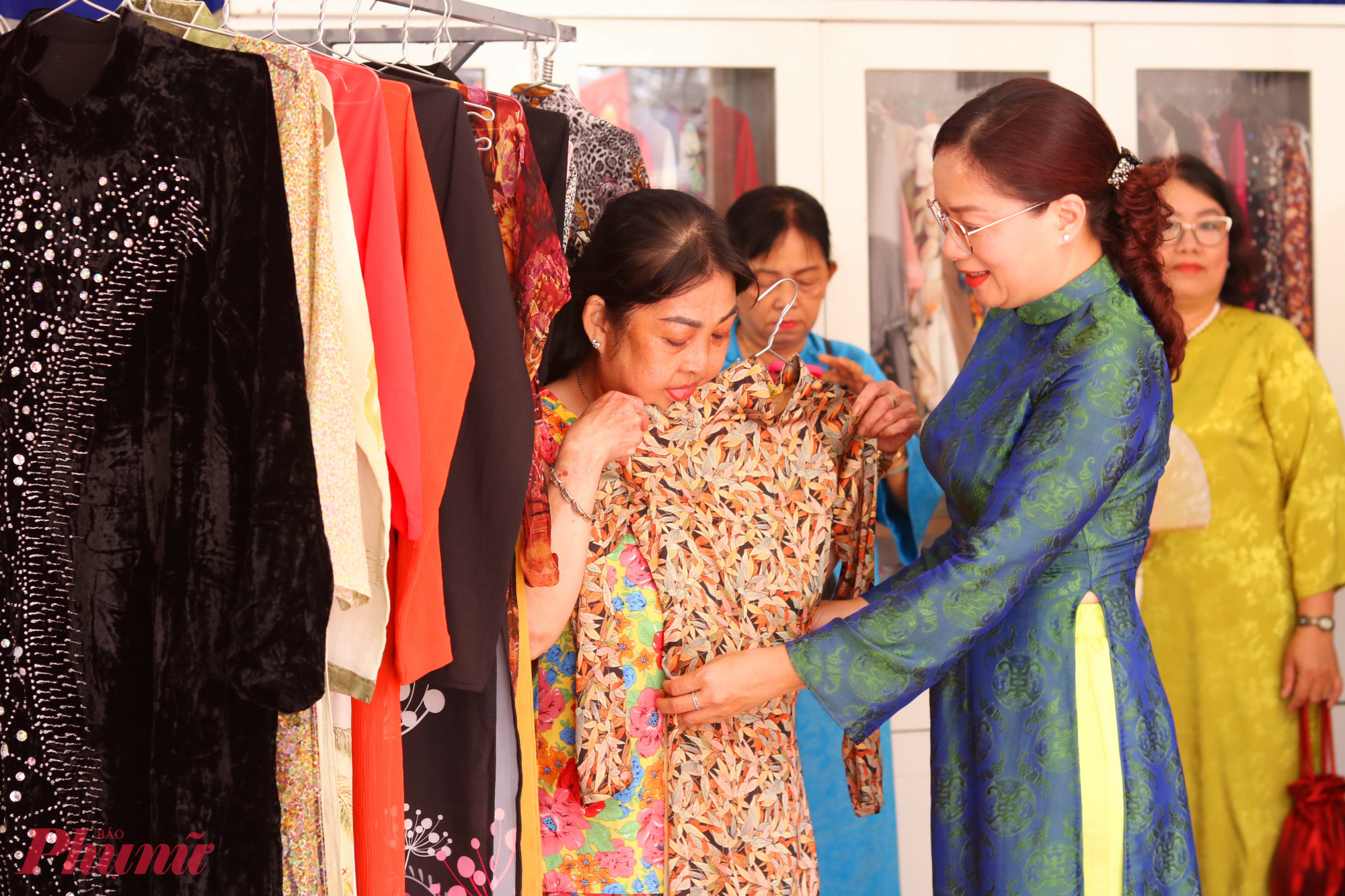 Bà Hoàng Thị Thu Liên – Chủ tịch Ủy ban MTTQ Việt Nam phường Sài Gòn (bìa phải) – dự buổi ra mắt gian hàng “Áo dài yêu thương” và hỗ trợ các dì, các chị chọn áo dài  - Ảnh: Mẫn Nhi